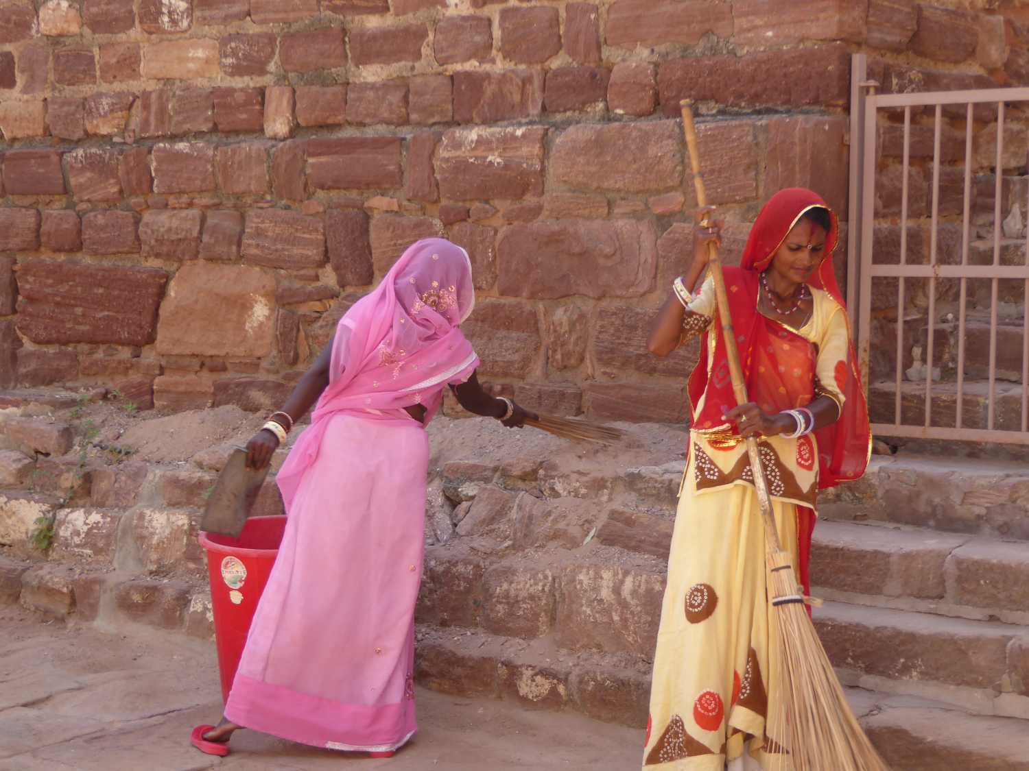 Beautiful women in gorgeous dresses - sweeping the courtyard